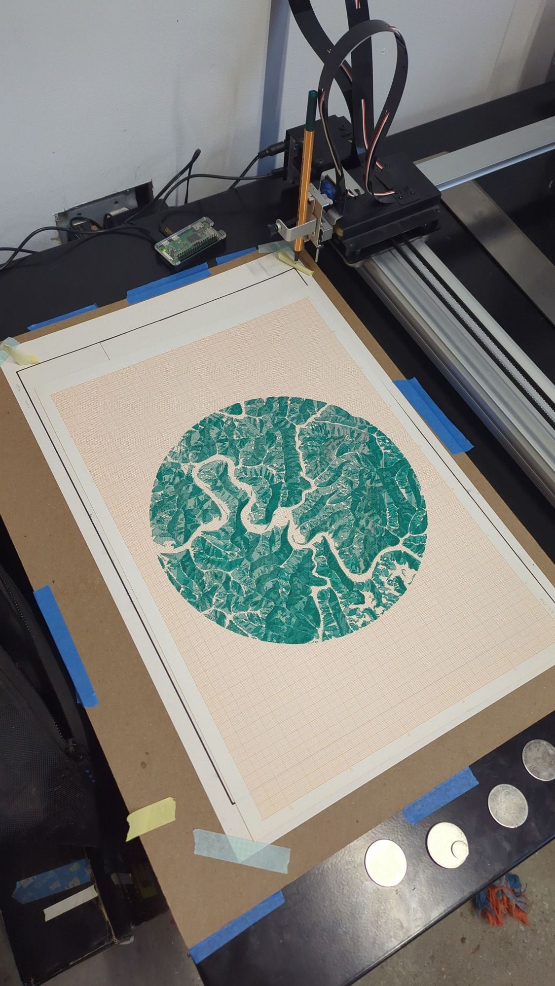 An A3 sized plotter drawing on orange graph paper of hillshade data from Matewan, West Virginia, drawn in dark teal ink